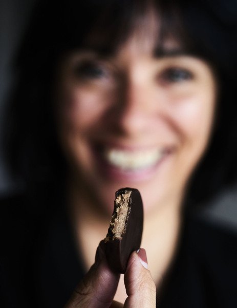 photo d’une femme qui tient une bouchée au chocolat noir