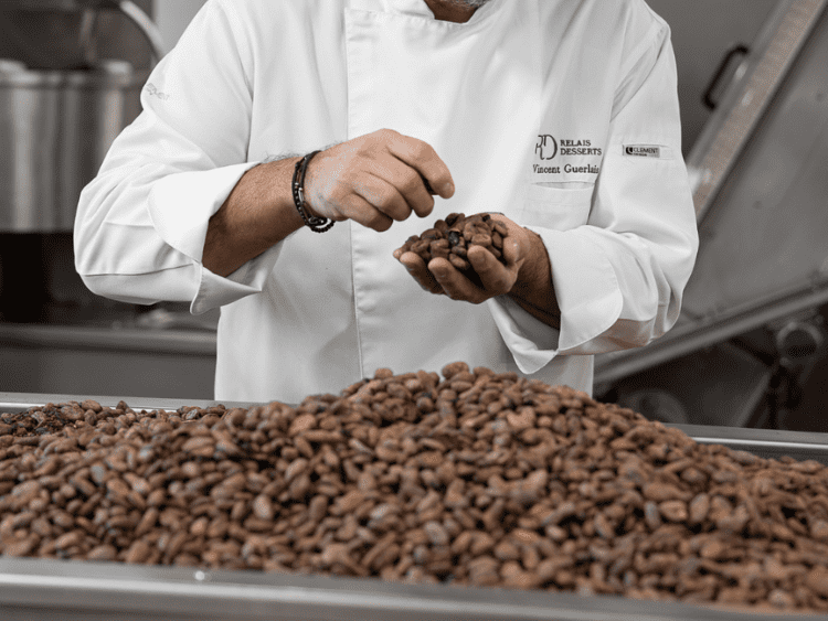 Photo d'un employé Guerlais qui confectionne des tablettes de chocolat à partir de fèves de cacao